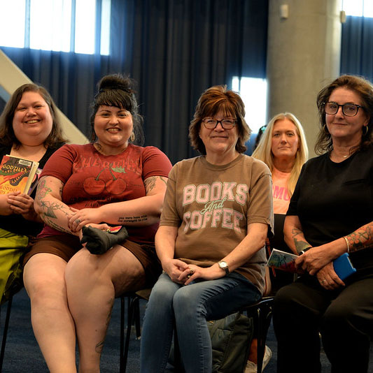 A group of adults smile as they sit together for OPL's Book Bash.
