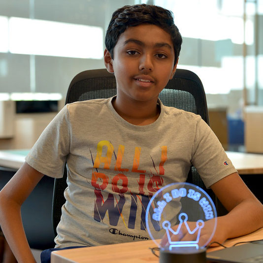 A teenager sits with their LED creation they made at a Do Space event.