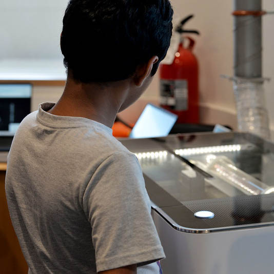 A teenager looks at a piece of equipment from Do Space while working on a project.
