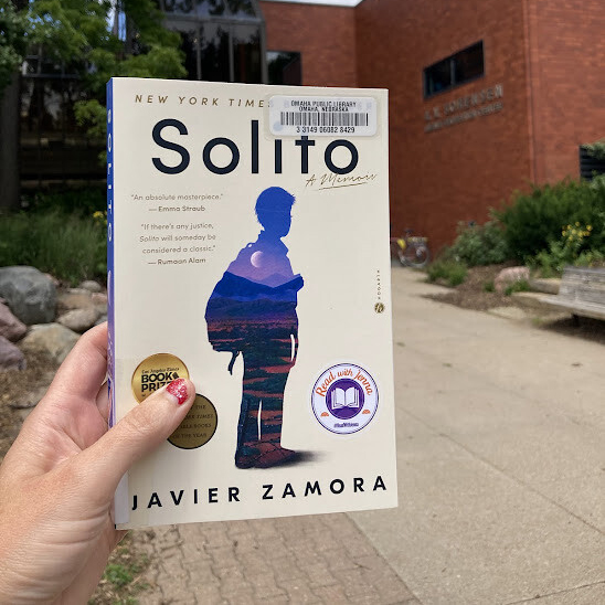 A hand holding a copy of the book 